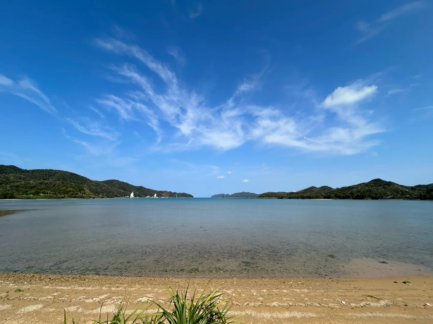 青い空の下、山々に囲まれた奄美の穏やかな海